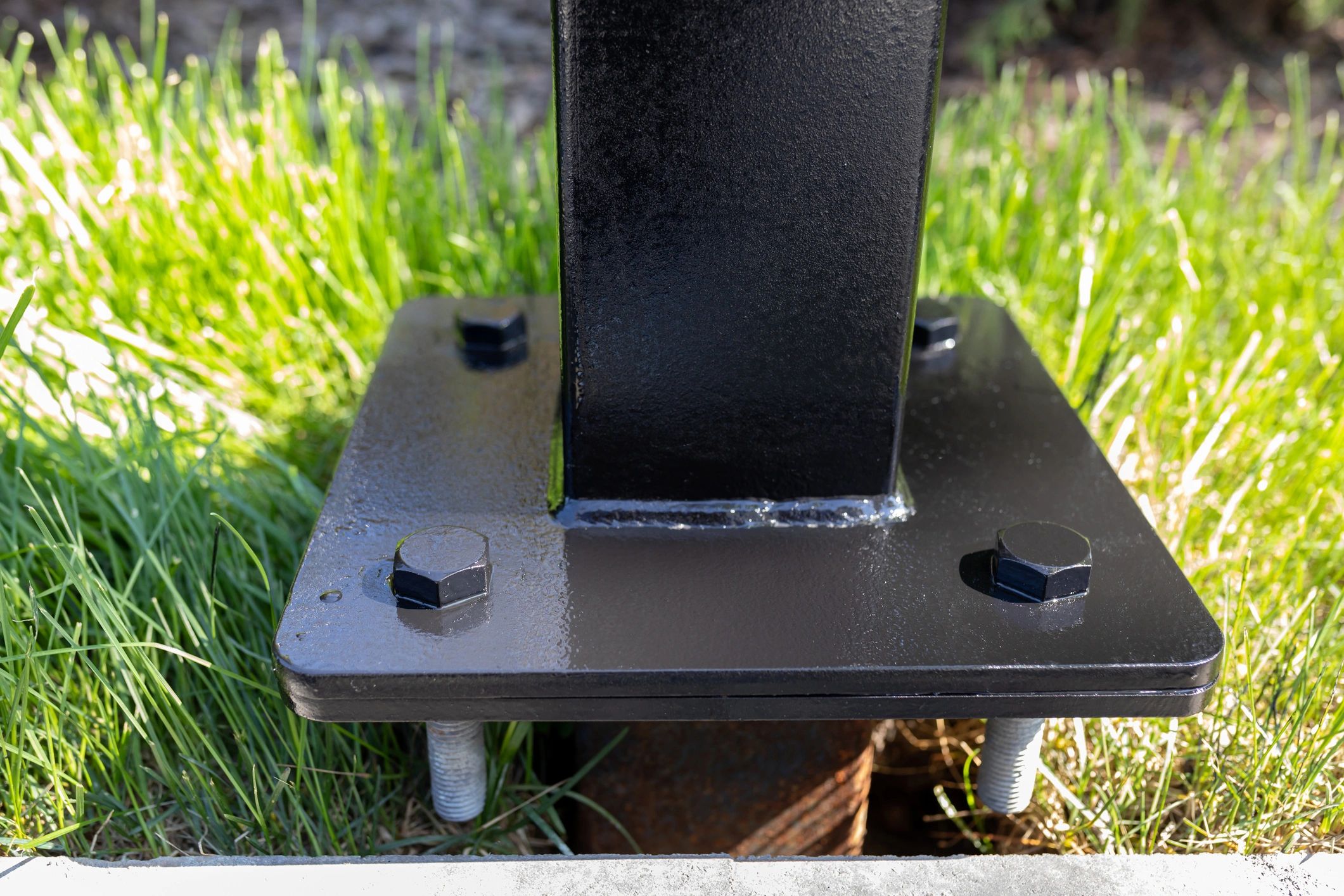 Metal post base secured with anchor bolts