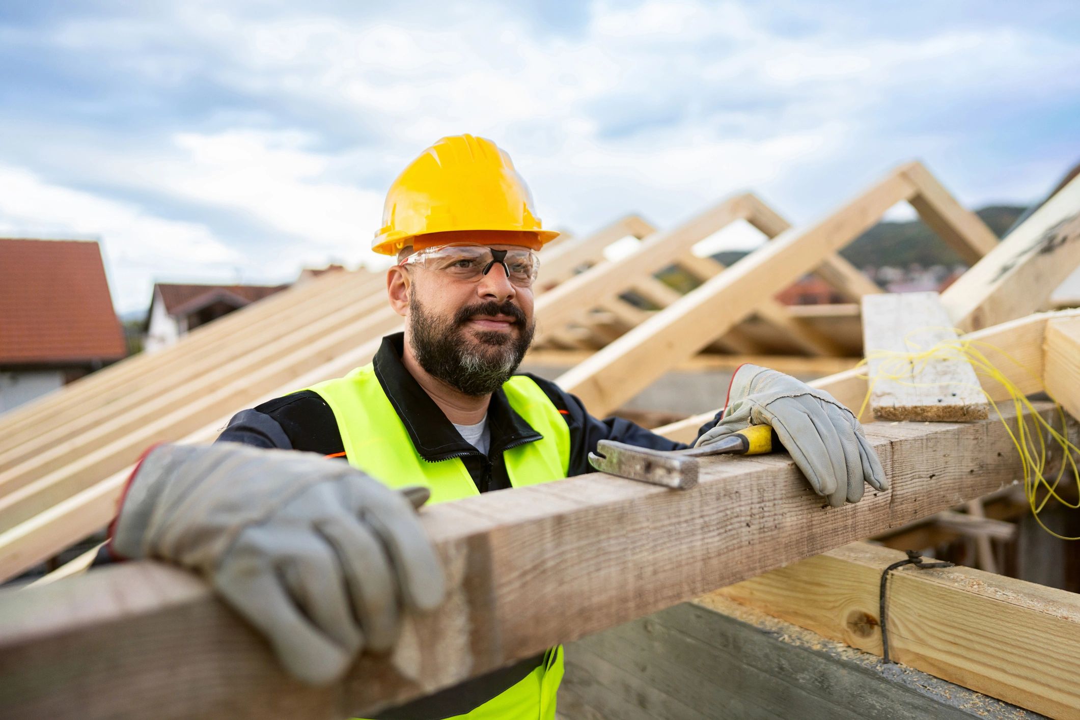 Roofer working on a roof beam at a construction site