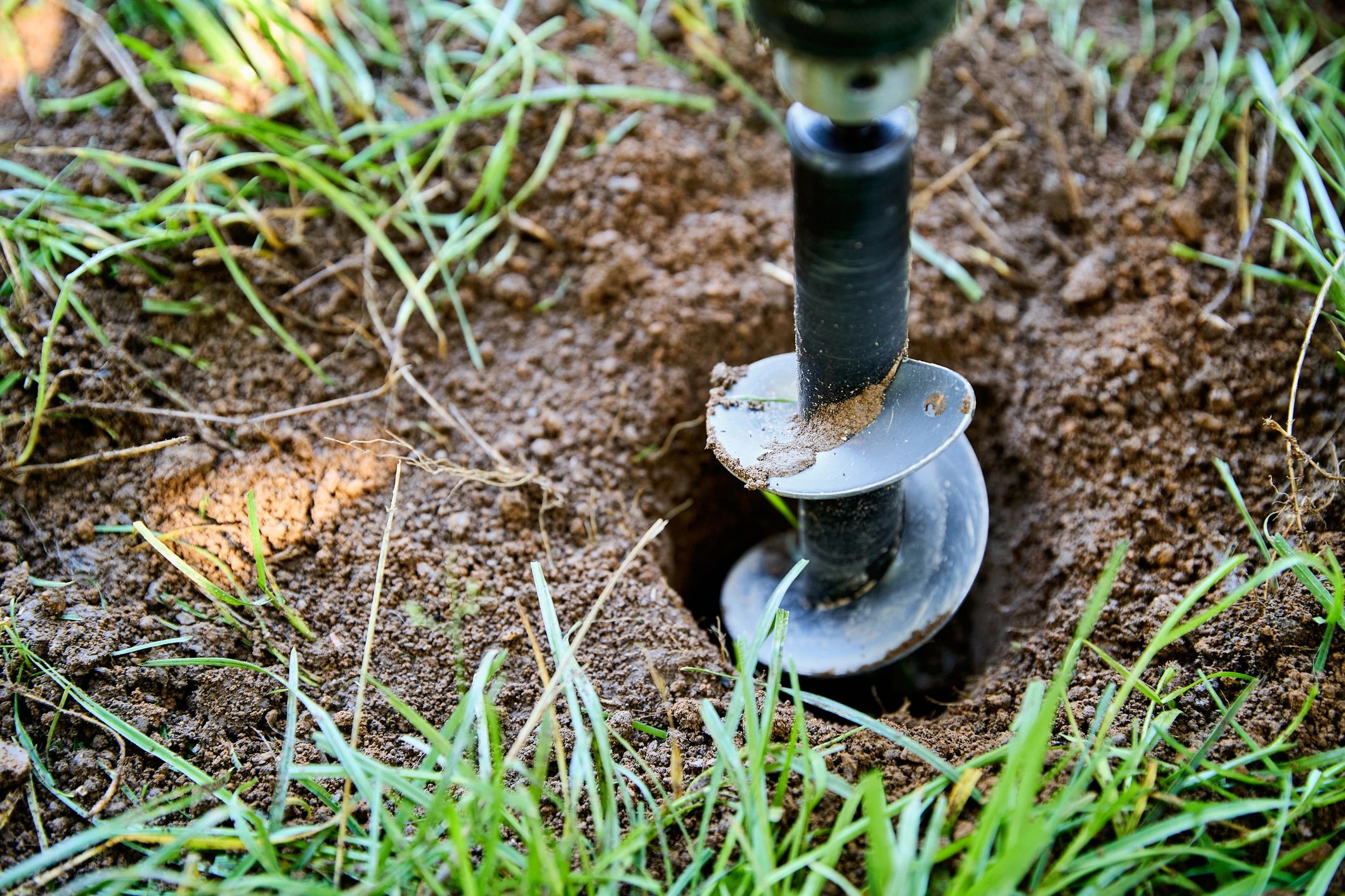 Auger drill bit digging in soil