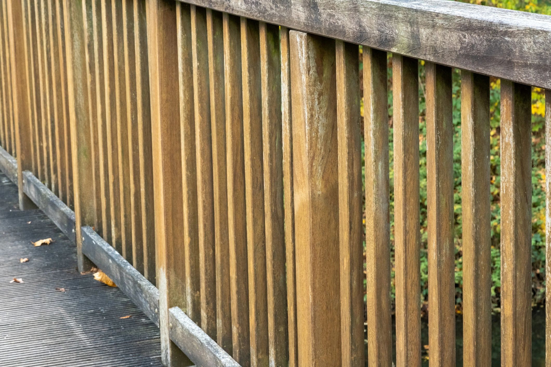 Weathered wooden bridge railing protecting outdoor pathway